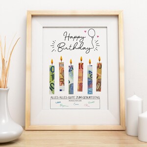 May include: A framed print with a light wood frame. The artwork features the words "Happy Birthday" above six candle-shaped designs made of Euro banknotes. The text "ALLES ALLES GUTE ZUM GEBURTSTAG" is below the candles.