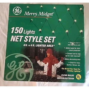 Puede incluir: Una caja verde de luces navideñas GE Merry Midget estilo red. La caja dice "150 Lights NET STYLE SET" con un área iluminada de 1,83 m x 1,22 m. La caja también indica que las luces son para uso en interiores/exteriores y tienen bombillas transparentes.