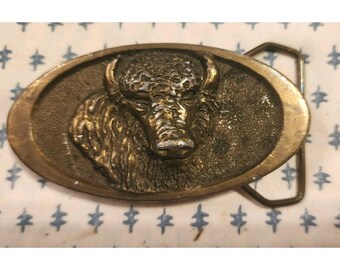 Fivela de cinto vintage com cabeça de búfalo em latão maciço, da A Dozy, 1976. Ornamentada e em relevo, rara.