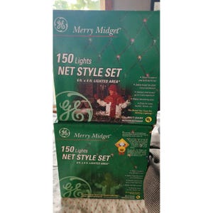 Puede incluir: Dos cajas verdes de luces navideñas GE Merry Midget estilo red. Cada caja muestra 150 luces y cubre un área iluminada de 1,83 m x 1,22 m. Las cajas están etiquetadas para uso en interiores/exteriores.