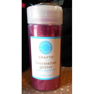 Puede incluir: Un recipiente de plástico transparente de purpurina turmalina Martha Stewart Crafts. El recipiente tiene una tapa blanca y una etiqueta con el logotipo de la marca e información del producto. La purpurina es de color rosa intenso y el recipiente contiene 130g.