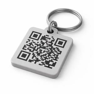 Op de afbeelding: Een vierkante, lichtgrijze sleutelhanger met een zwarte QR-code. Het label is bevestigd aan een zilveren metalen sleutelring. De sleutelhanger wordt getoond tegen een witte achtergrond.