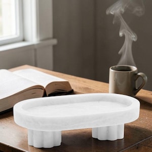 May include: A set of three ceramic mugs with a speckled, matte finish. The mugs are in shades of cream, light gray, and dark gray. Each mug has a simple, minimalist design, perfect for coffee or tea.