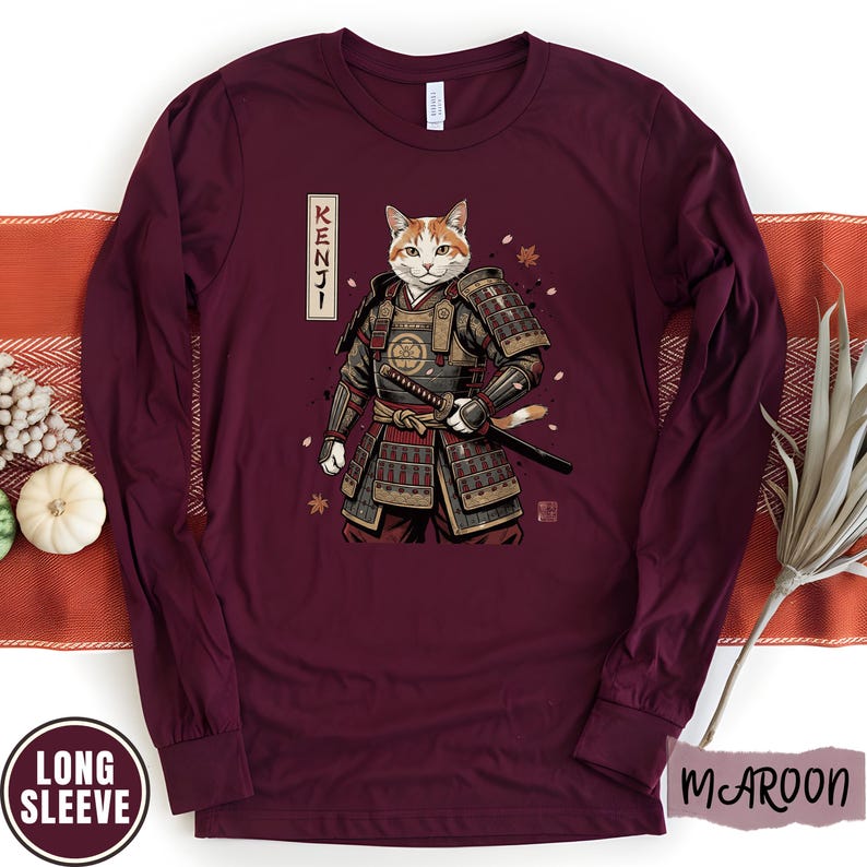 Puede incluir: Camiseta de manga larga color granate con un dise&ntilde;o de gato samur&aacute;i y la palabra japonesa "KENJI". El gato lleva una armadura tradicional y sostiene una espada. La camiseta tiene una etiqueta "LONG SLEEVE".