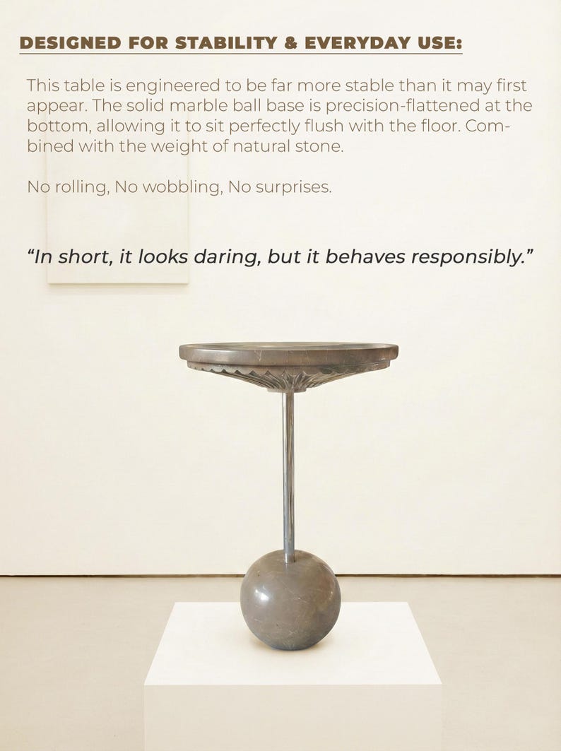 Pu&ograve; includere: Un tavolino moderno con un piano rotondo e un design unico. Il tavolo presenta una base a sfera in marmo grigio e uno stelo in metallo. Il testo recita "DESIGNED FOR STABILITY & EVERYDAY USE:" e "In short, it looks daring, but it behaves responsibly."