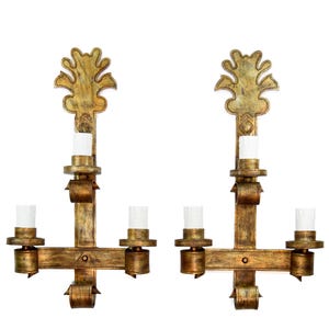 Peut inclure: Deux appliques murales dorées ornées avec une finition vieillie. Chaque applique présente un dessus décoratif, trois bougeoirs avec des ampoules blanches en forme de bougie et des détails en volutes. Les appliques sont conçues pour être fixées au mur.