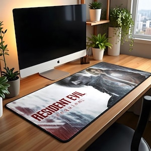 May include: A rectangular desk mat featuring the text "RESIDENT EVIL requiem" in red and white. The mat has a black border and a graphic of a woman and a monster. The mat is on a wooden desk.