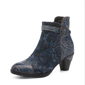 Peut inclure: Bottine bleue avec motif floral. La chaussure a un bout pointu, un petit talon et une boucle latérale. Le design incorpore des nuances de bleu et de beige, créant une esthétique vintage. Le talon mesure environ 5 cm.