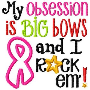 May include: Embroidered design with the text "My obsession is big bows and I rock em!" in black, red, green, and pink lettering. A pink ribbon is featured on the left side of the design.
