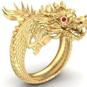 May include: A gold-colored dragon ring with intricate details. The dragon's head features a red gemstone eye and open mouth. The ring's design wraps around the finger, showcasing the dragon's scales and form. A unique piece of jewelry.
