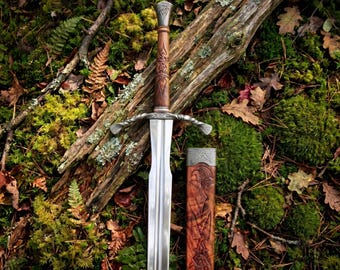 May include: A steel sword with a double-edged blade and a twisted metal crossguard. The handle is crafted from brown wood featuring intricate carved knotwork patterns. Beside the sword lies a matching wooden scabbard with metal accents.