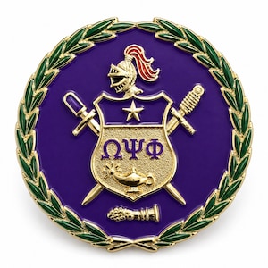Puede incluir: Un emblema circular de metal dorado con un fondo de esmalte morado y un borde de corona de laurel verde. El centro muestra un escudo con un casco de caballero, una estrella, las letras griegas Omega Psi Phi y una lámpara de aceite.