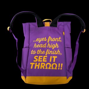 May include: Purple backpack with yellow accents and the text "...eyes front, head high to the finish, SEE IT THRO&Omega;!!" The backpack has two side pockets, a zippered front pocket, and adjustable straps.
