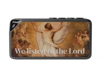 Può includere: Un altoparlante Bluetooth nero rettangolare con una griglia metallica perforata stampata con un dipinto religioso di una figura con le braccia alzate. Il testo bianco "We listen to the Lord" è stampato sulla parte inferiore.