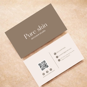 Puede incluir: Dos tarjetas de visita. La superior es color topo, la inferior es blanquecina. El texto dice "Pure skin skincare studio", datos de contacto, un código QR e iconos de redes sociales. Para un negocio de cuidado de la piel.