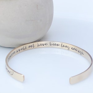 May include: Gold bangle bracelet with the inscription "forever would not have been long enough".