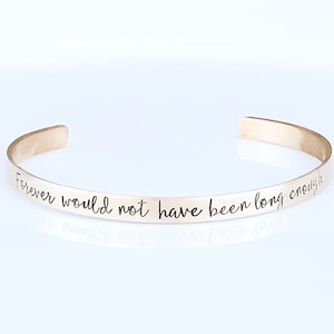 May include: A silver bangle bracelet with the inscription "Forever would not have been long enough".