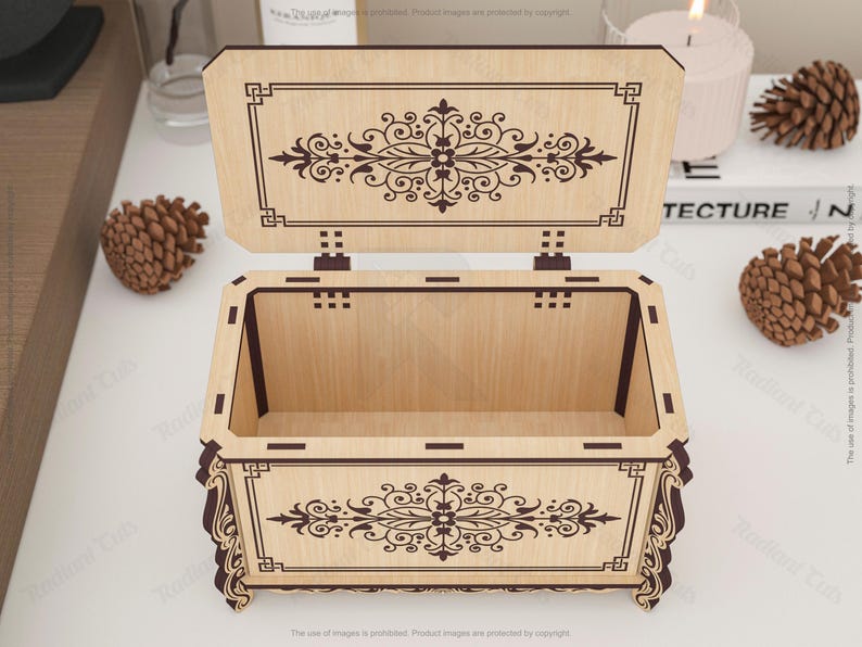 May include: Open wooden box with a hinged lid, featuring intricate dark brown floral and geometric designs. The box is light brown with dark brown accents and is open, revealing the interior. Decorative and ornate.