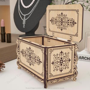 May include: A wooden jewelry box with an open lid, featuring intricate floral and geometric designs in dark brown against a light wood background. The box has a rectangular shape with curved edges and is displayed on a white surface.