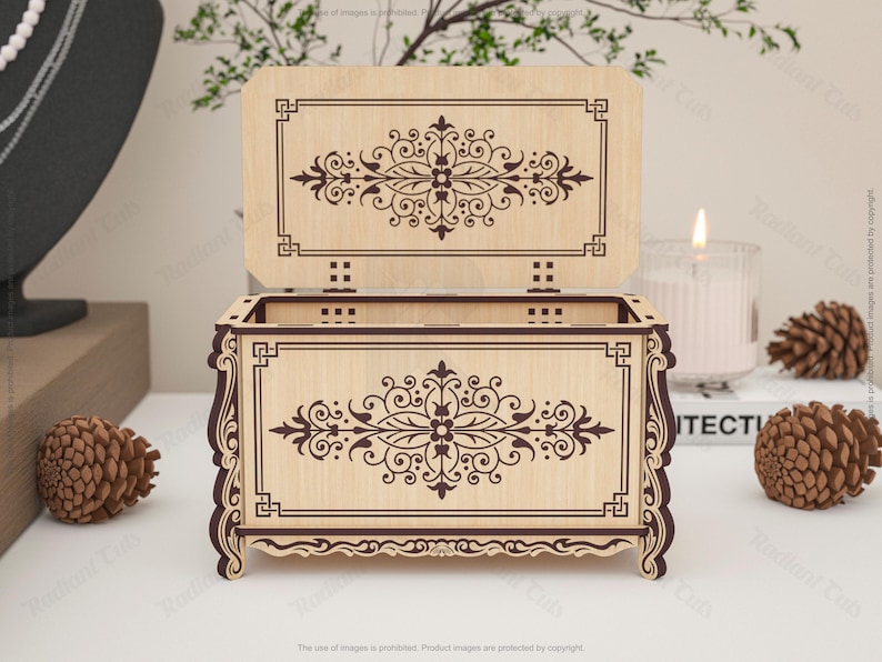 May include: A wooden decorative box with an open lid, featuring intricate floral and geometric patterns. The box is light brown with dark brown etched designs. The lid is open, revealing the interior. The box is on a white surface.