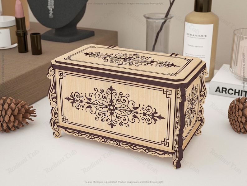 May include: A decorative wooden box with intricate floral and scrollwork designs. The box features a light wood finish with dark brown accents and a rectangular shape. The design is symmetrical and ornate, suitable for storing jewelry or small items.