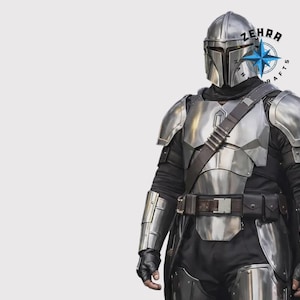 May include: A silver Mandalorian armor set, including a helmet, chest plate, shoulder pads, and arm guards. The armor is worn over a black undersuit with a brown belt and strap. The image includes the text "ZEHRA CRAFTS".