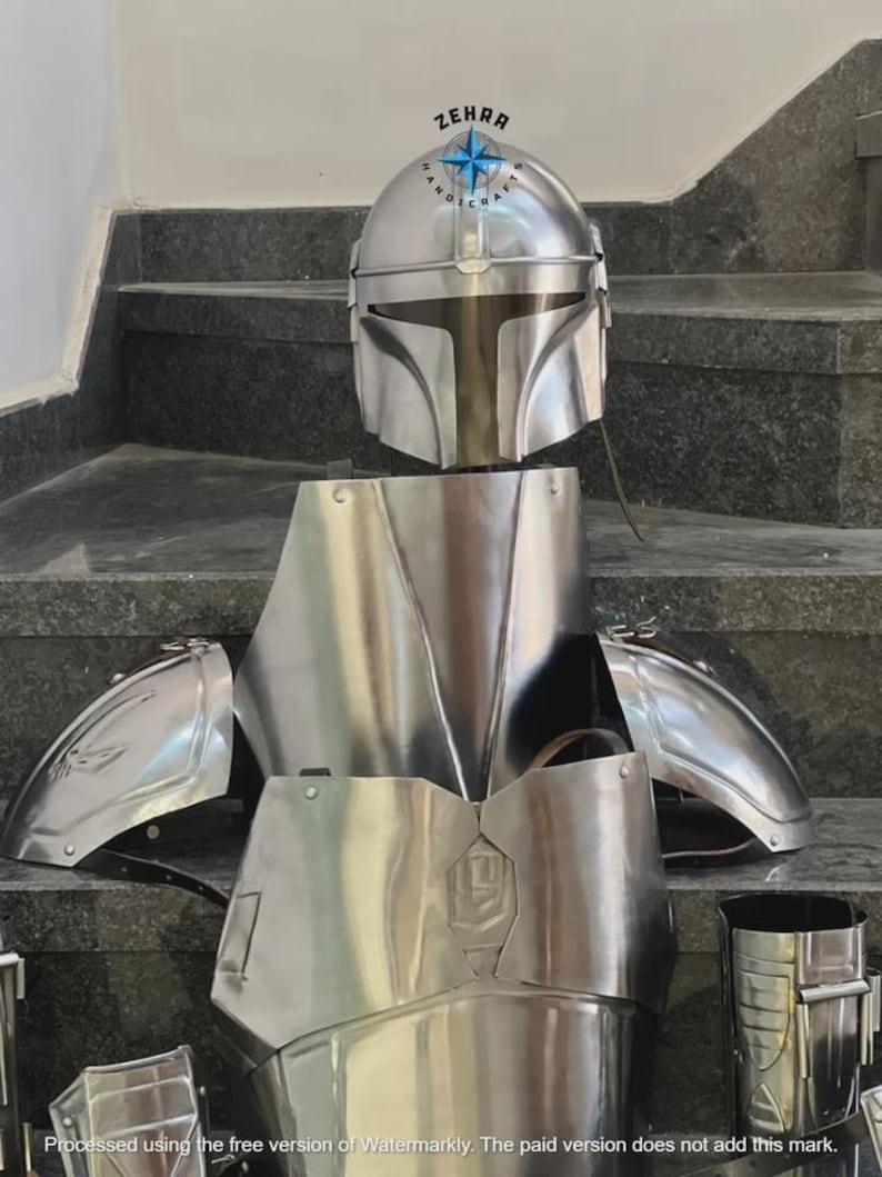 May include: A complete set of polished silver armor, including a helmet, chest plate, shoulder guards, and leg pieces. The helmet has a distinctive T-shaped visor. The armor is displayed on a set of stairs.