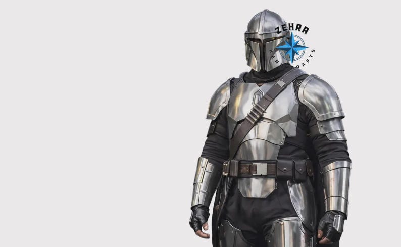 May include: A silver Mandalorian armor set, including a helmet, chest plate, shoulder pads, and arm guards. The armor is worn over a black undersuit with a brown belt and strap. The image includes the text "ZEHRA CRAFTS".