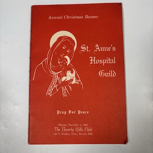 May include: A red brochure with white text and illustrations. The cover reads "Annual Christmas Bazaar" and features an image of Mary holding baby Jesus. The text "St. Anne's Hospital Guild" is also present, along with "Pray For Peace".