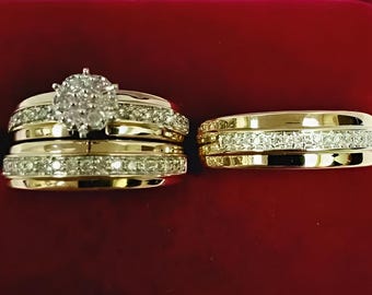 May include: A set of gold-toned rings with sparkling diamond accents. One ring features a cluster of diamonds, while the others have a band of smaller stones. The rings are displayed in a red velvet box, showcasing their elegance.