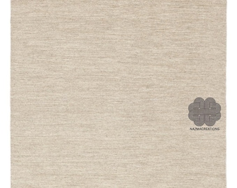 May include: A rectangular, beige rug with a textured surface. The rug has a woven appearance and a lighter border. The Nazmacreations logo is in the bottom right corner.