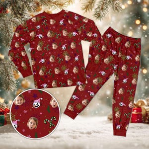 May include: A long-sleeve shirt and pants pajama set in deep red featuring an all-over pattern of repeating human faces, stylized skull characters in pink hats, green candy canes, purple stars, and thin spider web designs across the fabric.