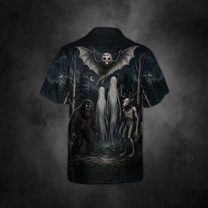 May include: A short-sleeve button-down shirt in black featuring a dark, atmospheric forest scene. The graphic includes a large bat with a skull head, two tall ghostly figures, a hairy ape-like creature, and a skeletal deer-like entity.