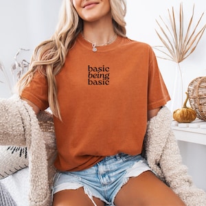 Basic being basic slogan t shirt in orange colorway, short sleeve crewneck tee for daily casual wear, simple phrase design