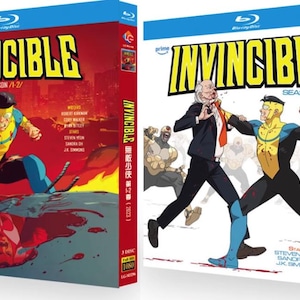 Könnte beinhalten: Zwei Blu-ray-Box-Sets der Zeichentrickserie "Invincible". Das erste Set ist rot mit dem Titel und einer Figur in einem gelb-blauen Anzug. Das zweite Set ist weiß mit dem Titel und zwei Figuren in einer Kampfszene.