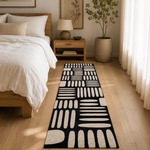 Modern black & ivory geometric runner rug at the foot of a Japandi bed, hand tufted wool bedroom runner for minimalist and Scandinavian home decor