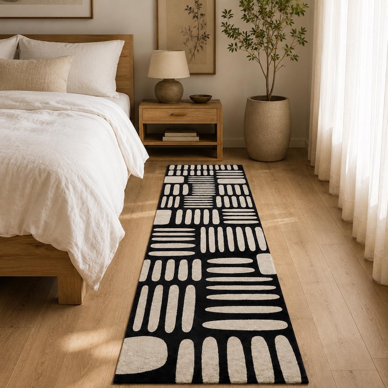 Modern black & ivory geometric runner rug at the foot of a Japandi bed, hand tufted wool bedroom runner for minimalist and Scandinavian home decor