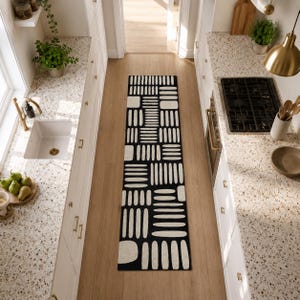 Black & ivory geometric kitchen runner rug between white cabinets, hand tufted modern wool runner for galley kitchen, hallway, and entryway decor