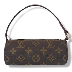 May include: Brown cylindrical handbag featuring a repeating pattern of gold logos and symbols. It has a brown leather handle and a gold zip. The bag is a small size, ideal for carrying essentials.
