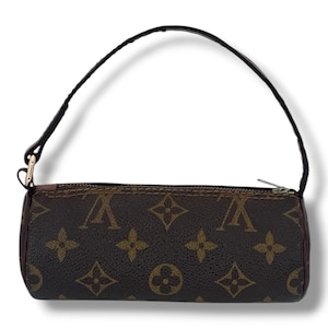 May include: Cylindrical brown and tan handbag with a black handle. The bag has a repeating pattern of interlocking shapes and letters. The silver zip and gold-coloured hardware attach the handle.