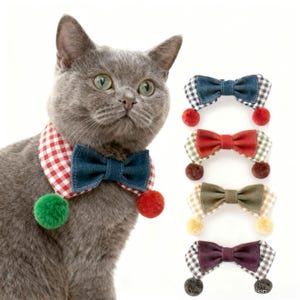 May include: A grey cat wearing a red and white gingham collar with a denim bow tie and green and red pom-poms. Four other bow ties with pom-poms in different colours are shown to the right.