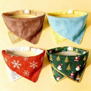 May include: Four pet bandanas in various colors and patterns. One is brown, one is blue, one is red with snowflakes, and one is green with Santa Claus and Christmas trees. Each has a white snap closure.