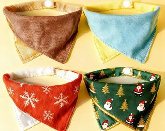 May include: Four pet bandanas in various colors and patterns. One is brown, one is blue, one is red with snowflakes, and one is green with Santa Claus and Christmas trees. Each has a white snap closure.