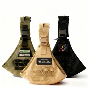 May include: Three triangular-shaped pet carriers in olive green, tan, and black. Each carrier has a zippered top, adjustable straps, and a buckle closure. The olive green carrier has a patch that reads "99%" and "1%", the tan carrier has a patch that reads "MAMA SAYS I'M SPECIAL", and the black carrier has a patch that reads "I LOVE DAD".