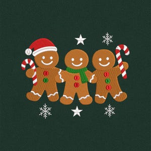 May include: An embroidered design featuring three gingerbread men on a dark green background. One gingerbread man wears a Santa hat and holds a candy cane. The other two hold candy canes and wear a green scarf. White stars and snowflakes complete the festive design.