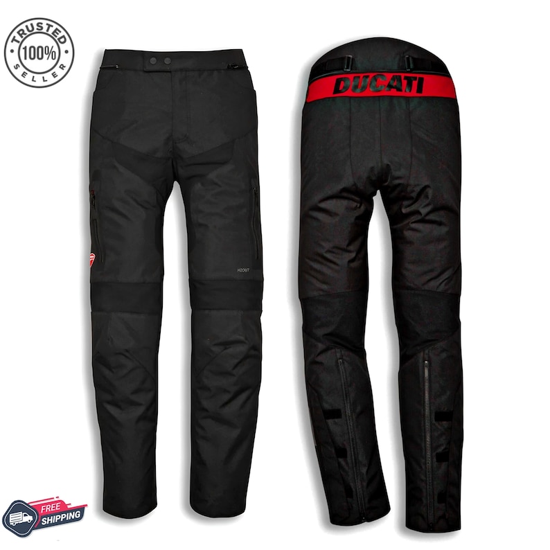 May include: Black motorcycle pants with a red "Ducati" band at the waist. The pants have reinforced panels at the knees and a small Ducati logo. The pants have a zipper at the bottom of the legs.
