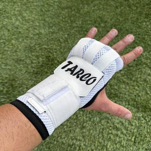 May include: White boxing hand wraps with the word "TARCO" in black lettering. The wraps have a mesh design for breathability and a hook-and-loop closure for a secure fit. The wrist area has a black trim.