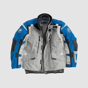 May include: A motorcycle jacket in shades of blue, gray, and white. The jacket features multiple pockets, a high collar, and the BMW logo on the sleeves. The jacket has a zip-up front and is designed for protection and style.