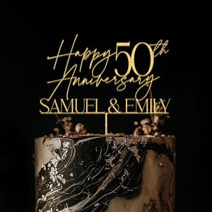 Könnte beinhalten: Zweistöckige Torte mit goldenem Aufsatz "Happy 50th Anniversary" über den Namen "Samuel & Emily". Die Torte hat ein marmorähnliches Design mit Goldblatt-Akzenten, passend für eine Hochzeits- oder Jubiläumsfeier.