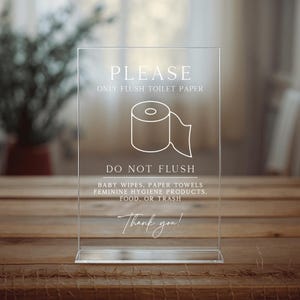 May include: Clear acrylic sign with the text "PLEASE ONLY FLUSH TOILET PAPER" and a toilet paper roll graphic. The sign also says "DO NOT FLUSH" and lists items not to flush. The sign ends with "Thank you!"